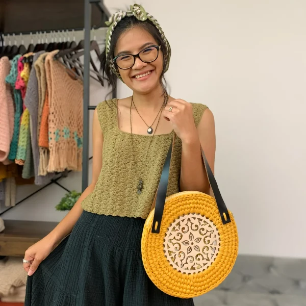 A woman waering a green crochet tank top with wide straps.