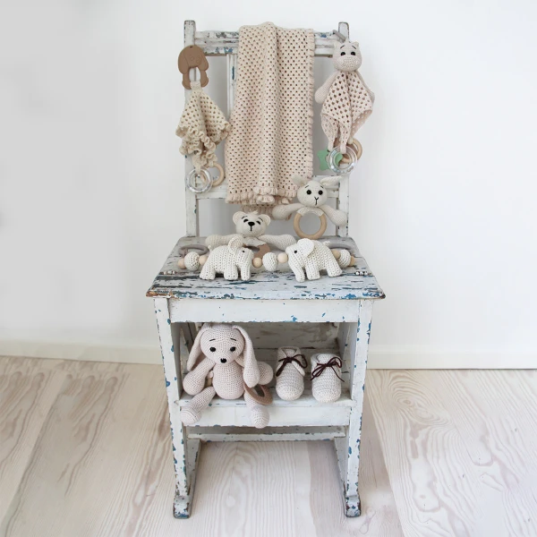 An elephant-themed crochet pram chain on a chair.
