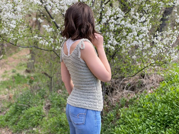 Woman wearing a crochet tank top with tie straps.