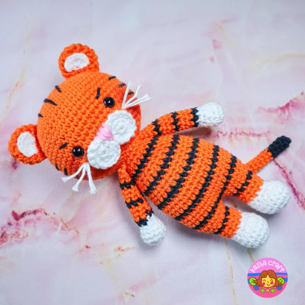A crochet tiger amigurumi toy with white whiskers.