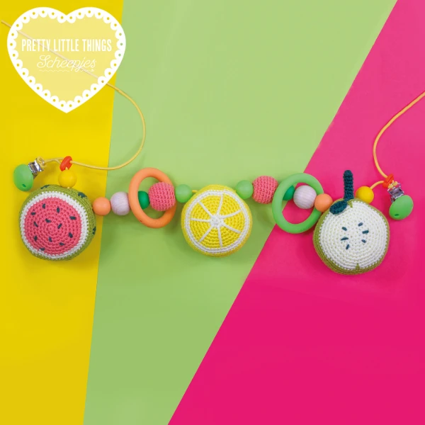 A fruit-theme crochet pram chain baby toy on a brightly coloured background.