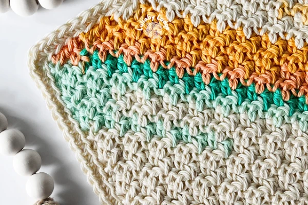 A crochet dishcloth made with self-striping yarn.