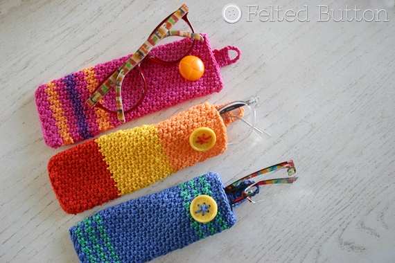 Three brightly coloured crochet glasses cases.