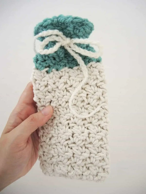 Crochet glasses case with drawstring closure.