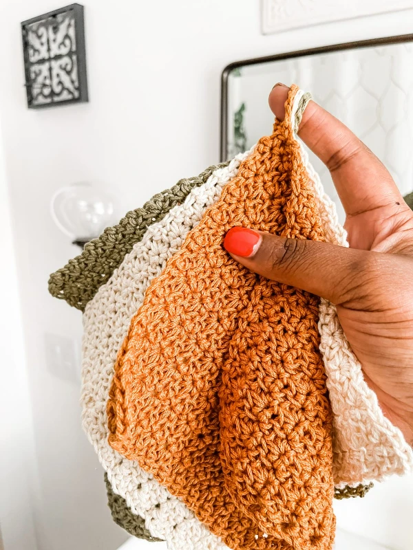 Crochet dishcloths with hanging loops in soft autumnal colours.