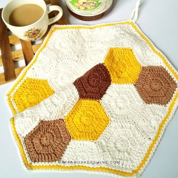 A honeycomb-themed crochet dishcloth made with hexagons.