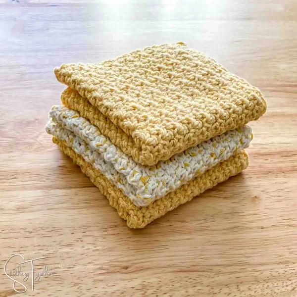 A stack of yellow crochet dishcloths.