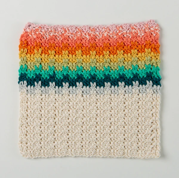 A striped crochet dishcloth made with small scraps of yarn.