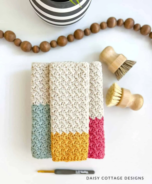 Three colour-blocked crochet dishcloths.