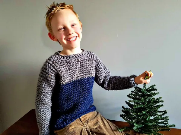 A child wearing a handmade crochet sweater.