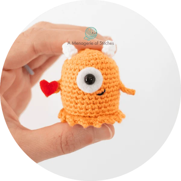 A miniature crochet love monster toy.