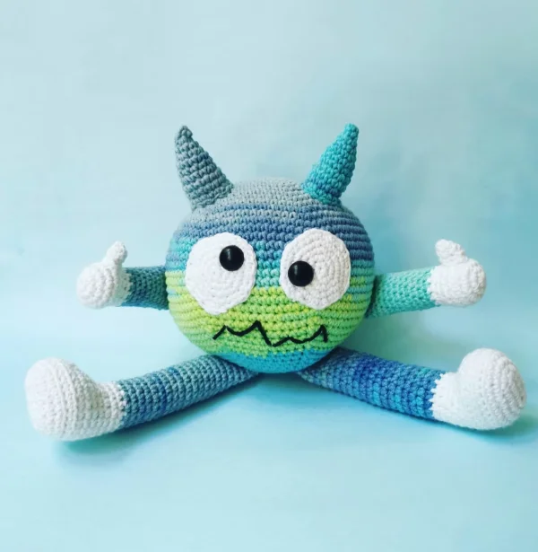 A cross-eyed crochet monsger with long legs and arms.