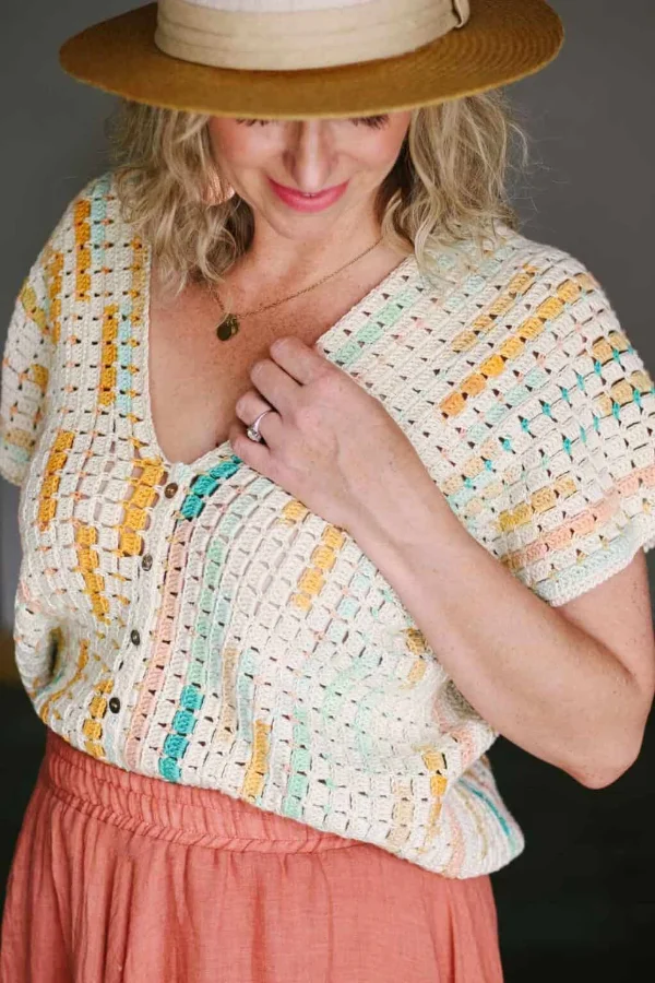 A woman waering a crochet tee made in variegated yarn.