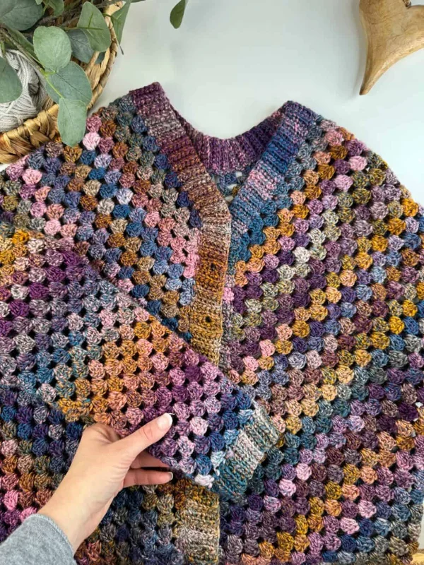 A flat lay image of a granny stitch cardigan in variegated yarn.